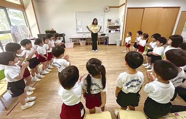 ホールで輪になって活動する園児たち