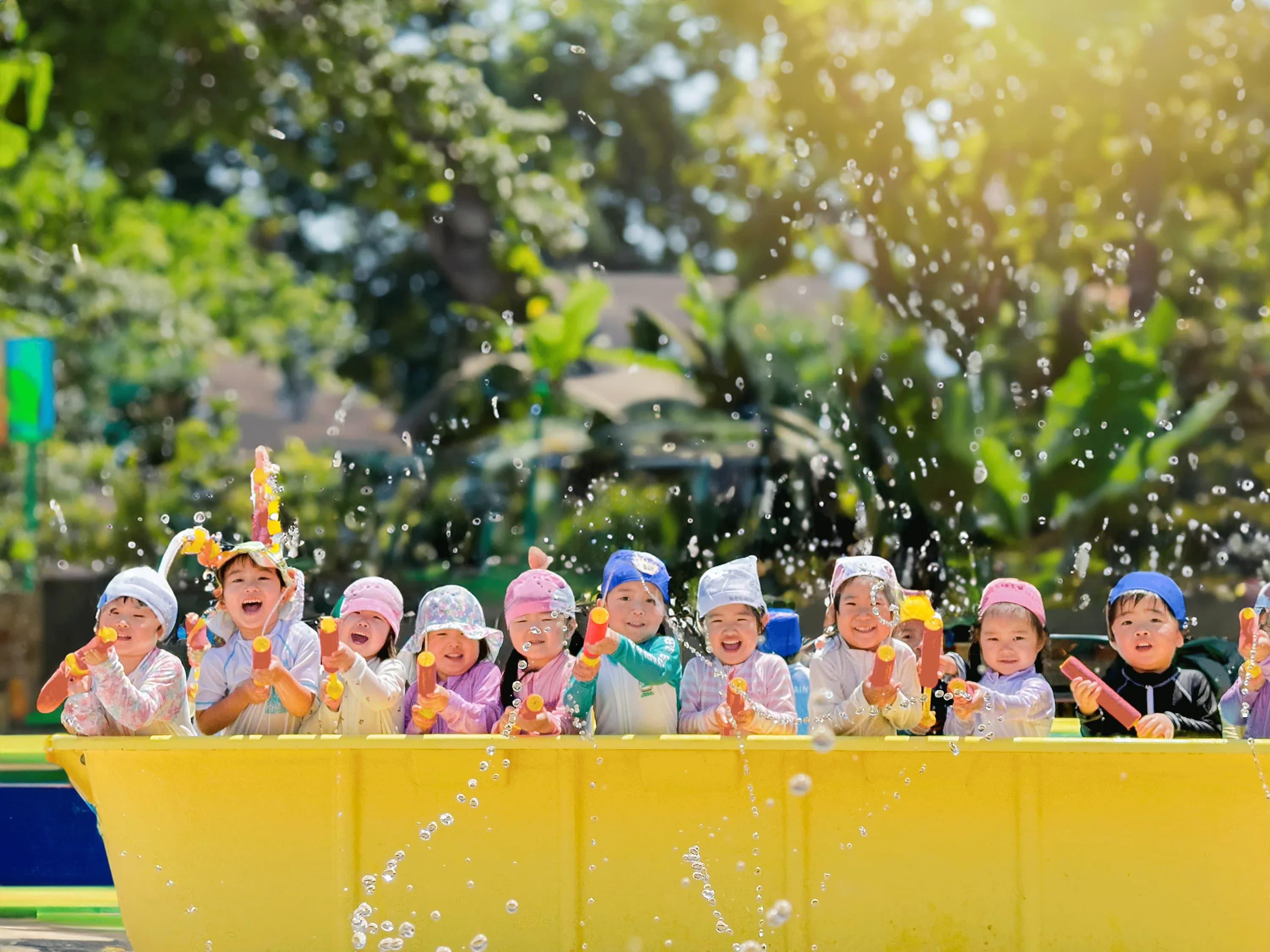 水鉄砲で水遊びをする園児たち