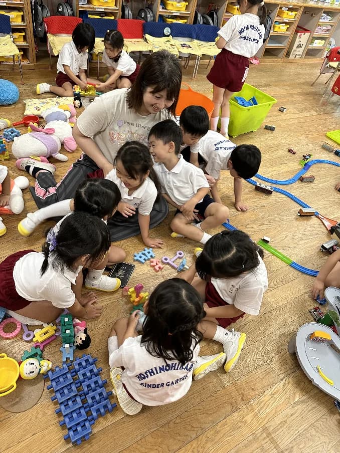保育室の床で遊ぶ園児たち